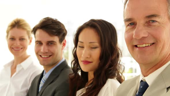 Business Team Smiling At Camera With Arms Folded