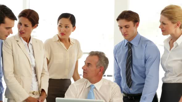 Business Team Talking In Front Of Laptop alt