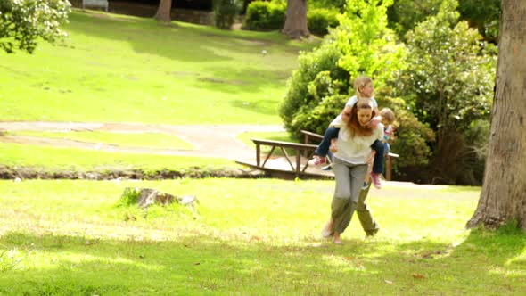 Happy Family Playing Chasing In The Park Together