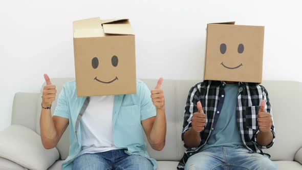 Silly Employees With Boxes On Their Heads Giving Thumbs Up alt