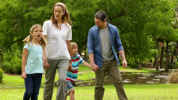Happy Family Walking In The Park Together