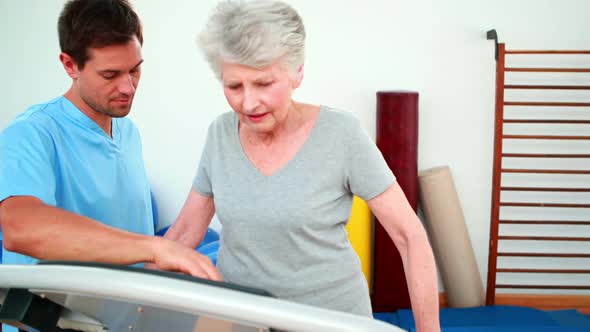 Physical Therapist Showing Patient How To Use Exercise Machine