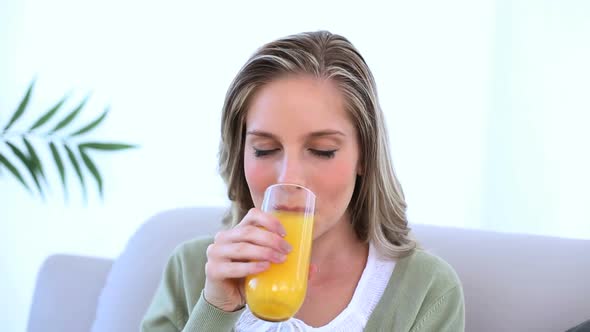 Beautiful Woman Drinking A Glass Of Orange Juice alt