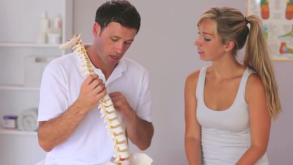 Physiotherapist Showing His Patient A Model Of The Spine