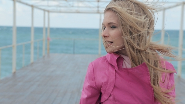 The Girl In a Coat Walking On The Pier
