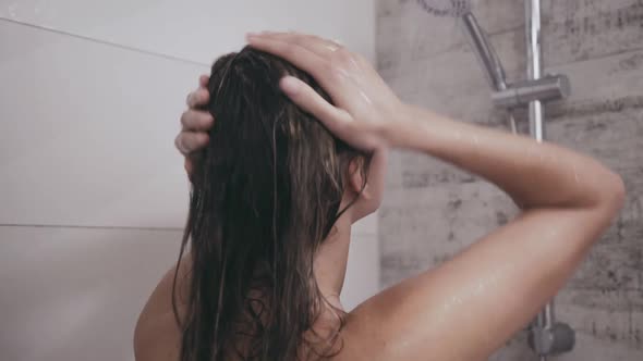 Back Look of Woman Cleansing Head Under Shower