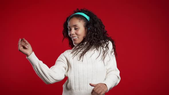 African Woman with Curly Hair Having Fun, Smiling, Dancing with Headphones