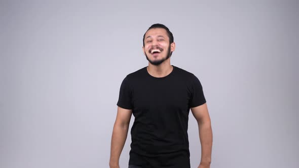 Happy young Indian man laughing and smiling