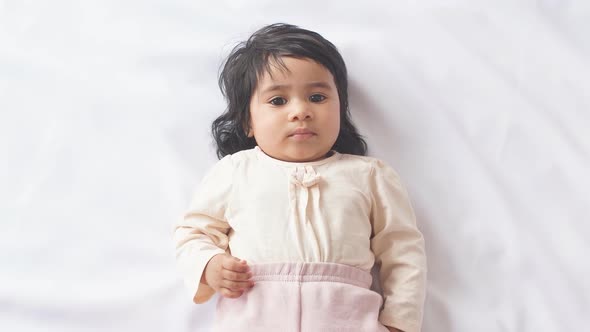 Happy African American Baby Girl Lying on Blanket at Home