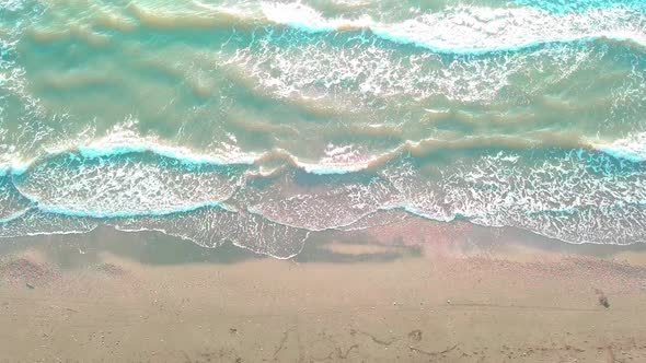 Drone view of the beautiful waves on the sandy beach,