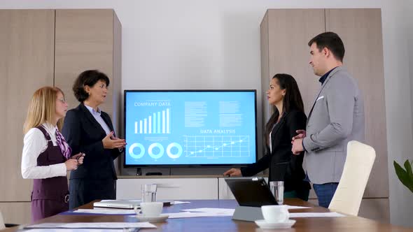 Business Team in Conference Room Beside a Big Screen TV