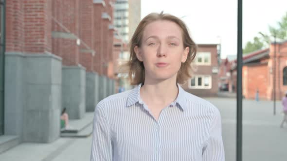 Excited Woman Talking on Online Video Call While Walking in Street