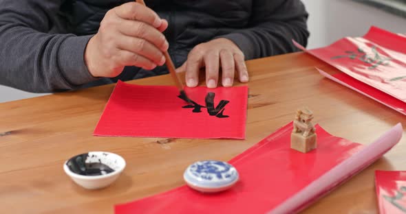 Man write chinese calligraphy for lunar new year