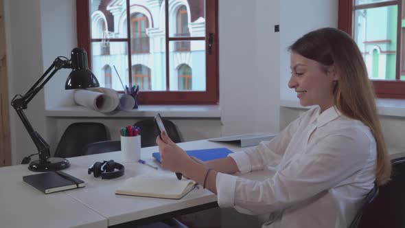 Woman Holding Tablet Smiling and Greeting Client