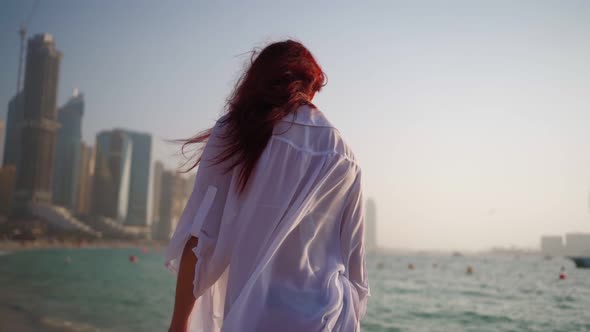 Woman in a White Shirt Walks Along the Beach of the Persian Gulf in Dubai