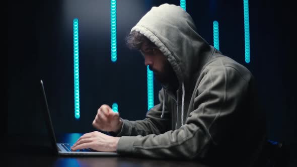 Side View of Pensive Hacker Man Looking at Laptop Screen Thinking Solving Problem at Dark Room