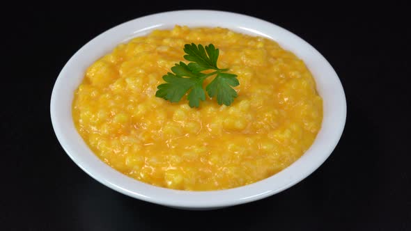 Pumpkin porridge with rice, milk and sugar in plate rotate, organic food