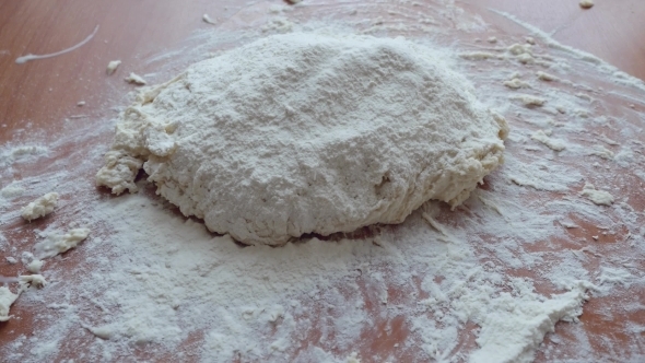 Hand Of Woman Adds Flour And Kneading The Dough On