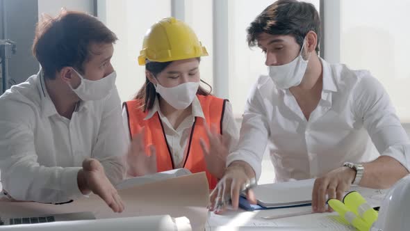 group of engineer caucasian male and asian female serious concentrate meeting with mask