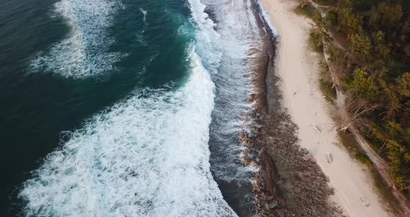 A drone shot of a beach on the north shore of Oahu. The shot moves forward and pans up