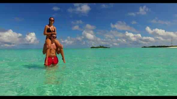 Young couple relax on perfect tourist beach adventure by blue green lagoon and white sand background