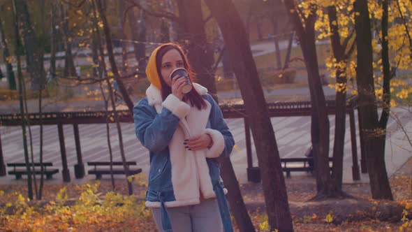Young Woman Drinking Coffee in Autumn Forest