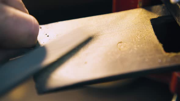 Jeweler Polishes Gold Rod and Cleans Workplace Closeup