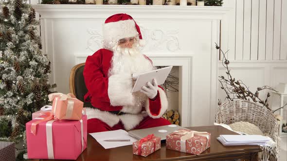 Santa Claus Using Tablet To Give a Quick Video Call To the North Pole