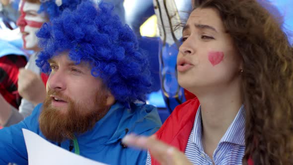 Caucasian Fan Couple Despairing at Missed Goal