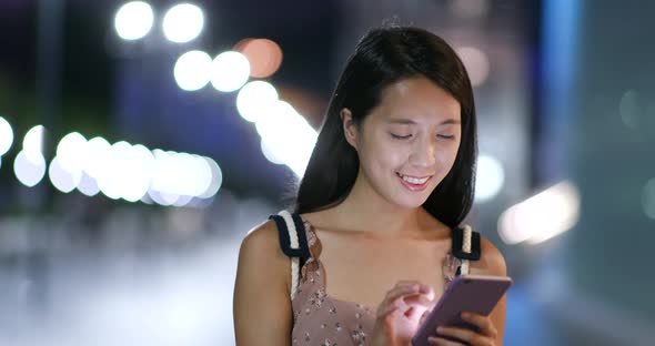 Woman use of cellphone with blur city  background