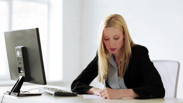 Business Woman Writing Application In Office