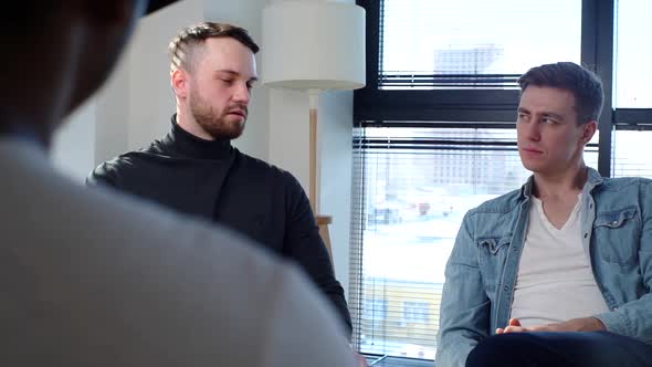 Hand Held Shot of Young Bearded Man Telling About Mental Problem to Other Patients Sitting in Circle