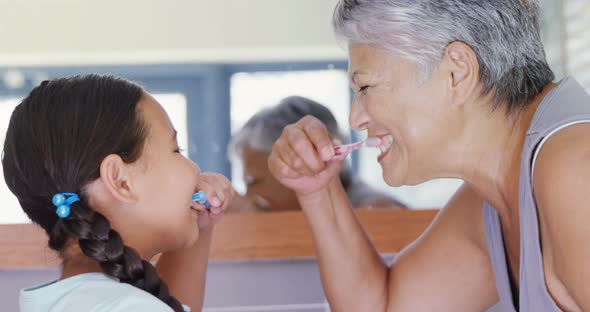 Grandmother and granddaughter brushing teeth in the bathroom 4k