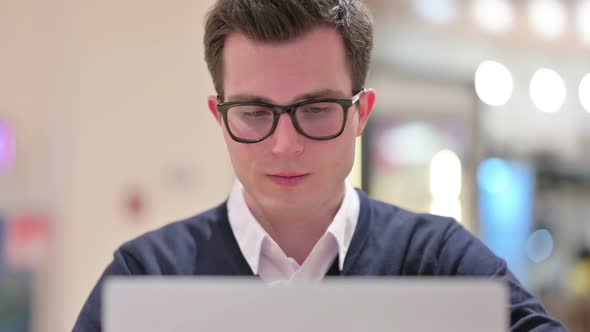 Young Businessman with Laptop Showing Thumbs Up