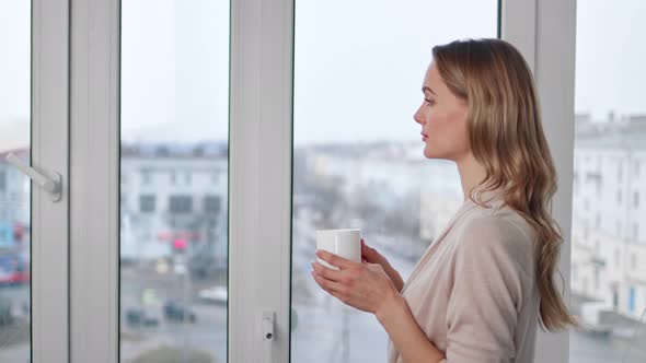 Thoughtful Young Girl Contemplating European City Street Holding Cup