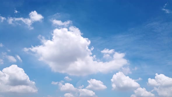 White puffy clouds and blue sky time-lapse with long second duration for background and graphics in