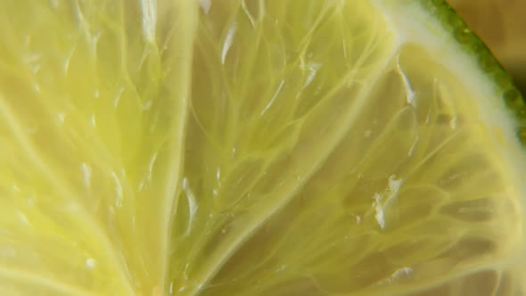 A Sliced Lime Slice Rotates on the Table. Macro Shot