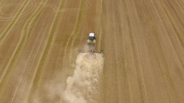 Tractor plows the field aerial. 