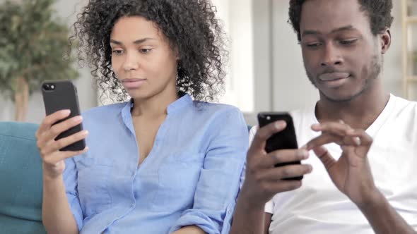 African Couple Using Smartphone Messaging