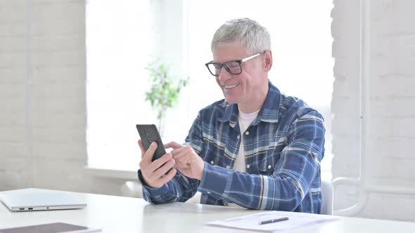 Casual Middle Aged Man Celebrating Success on Smartphone 