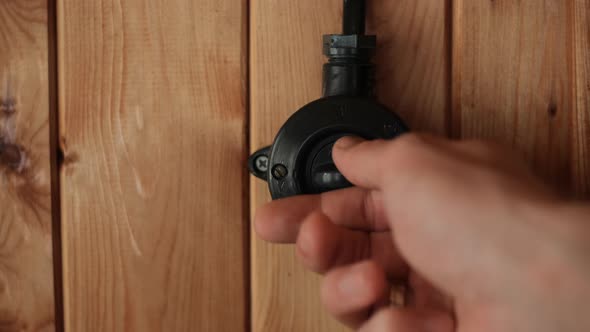 Retro Black Color Switch in Action Vintage Light Switch Turn on Manually on Wood Wall