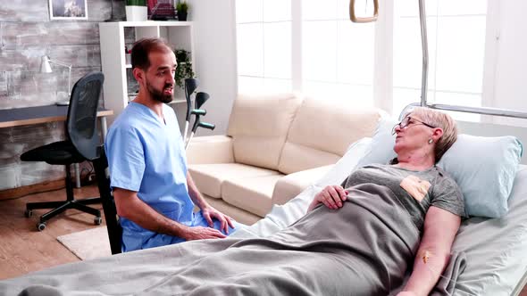 Caucasian Doctor in Nursing Home Talking with Old Woman