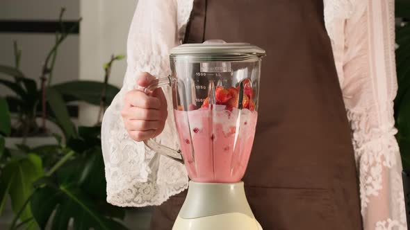 Making fresh fruits smoothie with red strawberries. Smoothie with fresh strawberry and milk