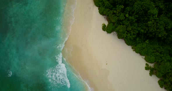 Beautiful birds eye abstract shot of a white sand paradise beach and turquoise sea background in col