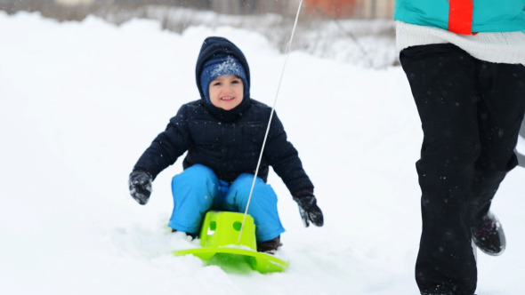 Little Boy Enjoying Riding on Sledge