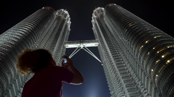 Woman Taking Picture Of Petronas Twin Towers With