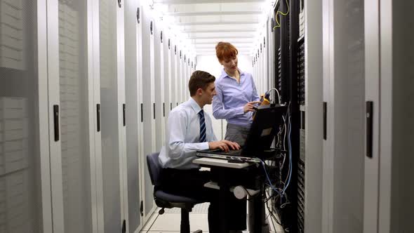 Technicians using digital cable analyzer on server