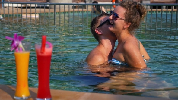 Happy Couple Having Fun In Swimming Pool In
