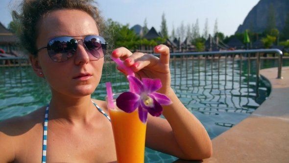 Girl Drinking Fresh Mango Juice In Luxury Pool On