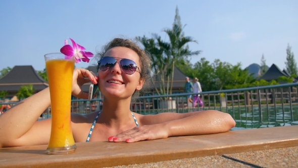 Young Woman Talking On The Phone In Pool